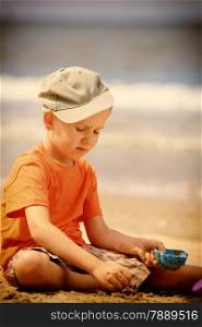 Child in action little boy playing toys on beach sea background