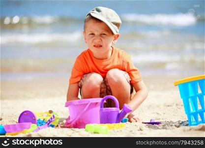 Child in action little boy playing toys on beach sea background