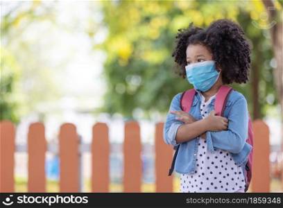 Child in face mask going at reopen school after covid-19 quarantine and lockdown. It is new normal for protection and prevention while outbreak of coronavirus or flu. Kids back to school concept.