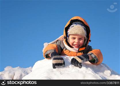 child lies on snow hill