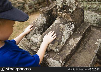 Child Looking at Feet of Ancient Statue