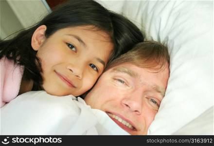 Child lying with parent in bed