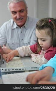 Child on a laptop with her grandfather