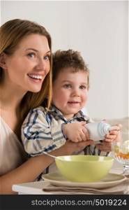 Child on breakfast - making a fruit salad with cream with his mother