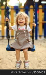Child on swing in summer park