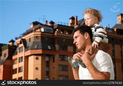 child on the shoulders of the father