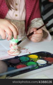 Child painting a plaster figurine