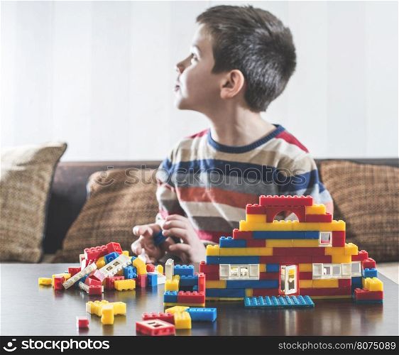 Child play with children's constructor toys. Multicolored cubes