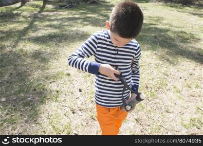 Child play with sling toy in the forest.