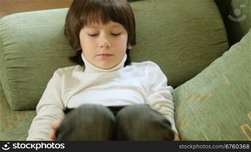 Child Playing Computer Games On Tablet Pc At Home
