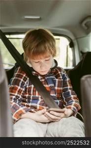 child playing smartphone car while road trip