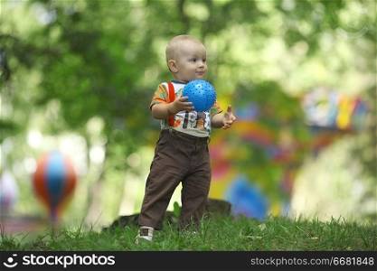 child playing with Ball in a summer park