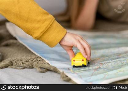 child playing with car toy map