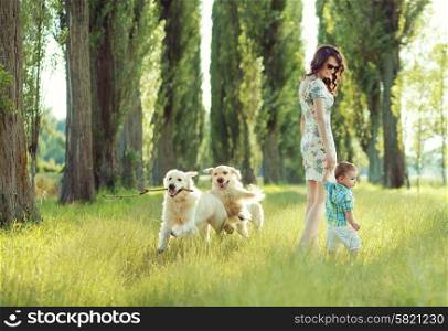 Child playing with mom and happy dogs