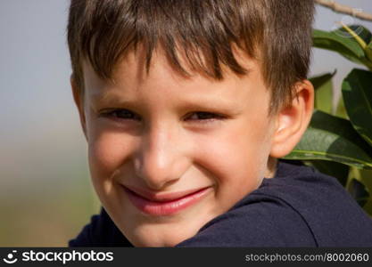 Child plays a cheerful smile without showing teeth