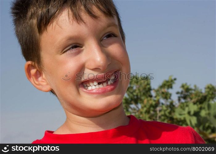 Child plays a cheerful smile without showing teeth