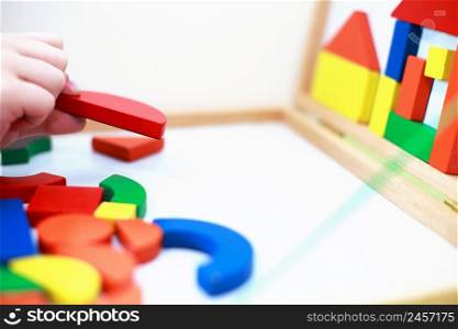 child plays wooden magnetic educational game. child plays with a toy on a white background. kid plays with a constructor. child plays wooden magnetic educational game. child plays with a toy on a white background.