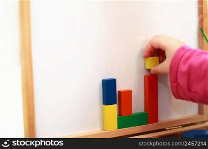 child plays wooden magnetic educational game. girl plays with a toy on a white background. kid plays with a constructor. child plays wooden magnetic educational game. girl plays with a toy on a white background