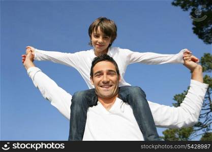 Child riding on his father&rsquo;s shoulders