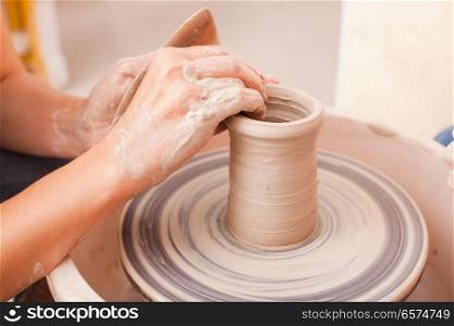 Child&rsquo;s ceramic handicrafts. Hands of girl who makes pottery from white clay on a potters wheel. Child&rsquo;s ceramic handicrafts