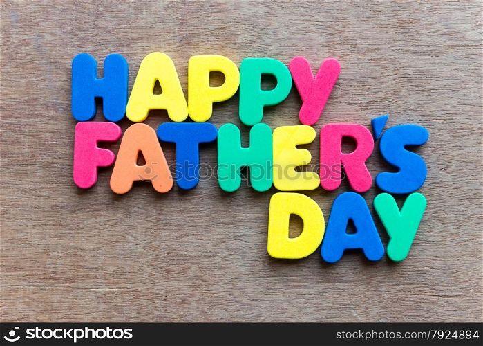 Child&rsquo;s toy letters spelling Happy Fathers Day over wooden background