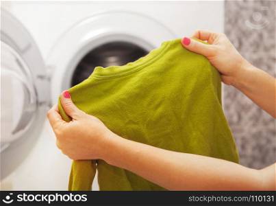 child?s clothes, which is in the hands of a woman hoo is going to wash it
