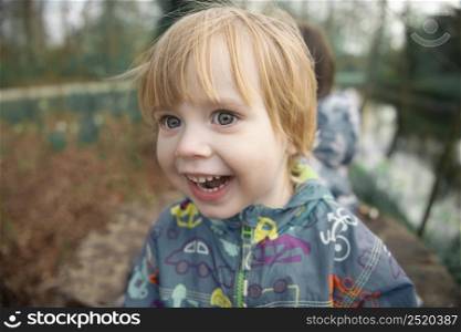 Child smiles face portrait on blurry background, outdoor