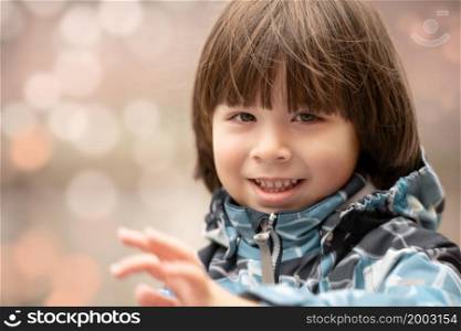 Child smiles face portrait on bokeh backgound, outdoor