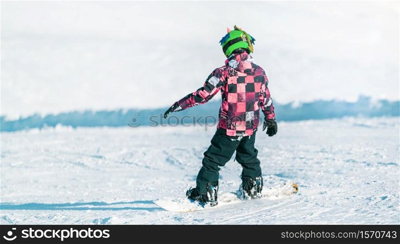 Child Snowboarding in the Mountains