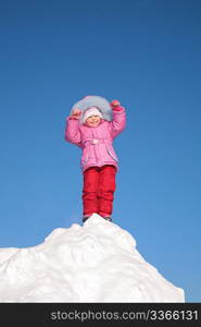 child stands on the top of the snowy hill