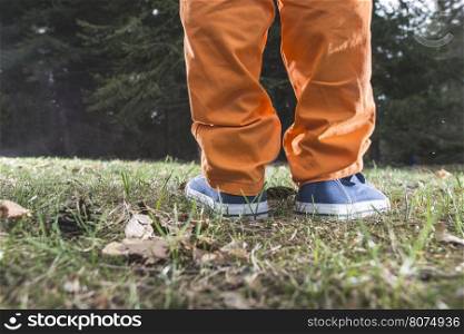 Child walking in the forest. Close up shoes