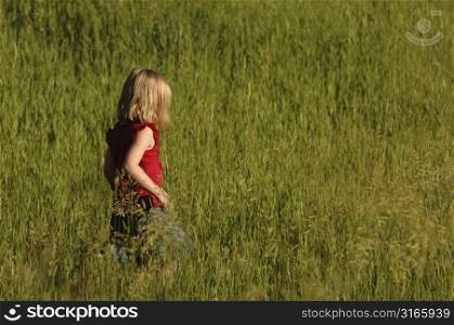 Child walking though tall grass