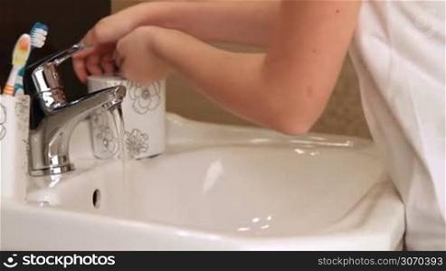 Child washing her hands in the bathroom. Learning good habits.