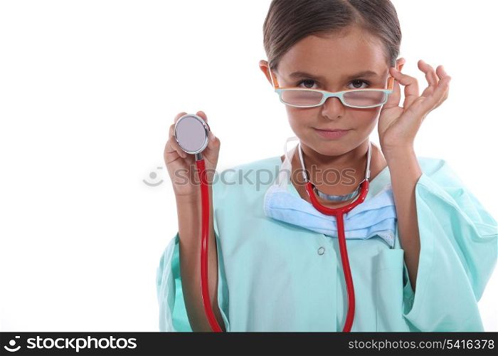 Child wearing grown up hospital scrubs, glasses and a stethoscope