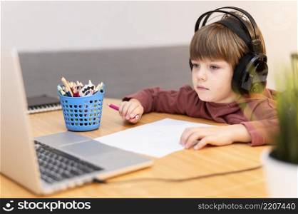 child wearing headphones attending online school