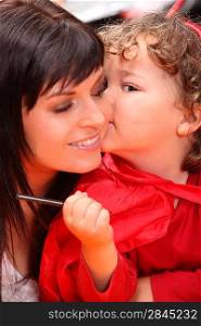 Child whispering into her mother&acute;s ear
