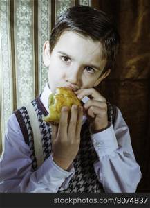 Child who eat donut. Vintage clothes and background