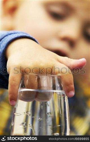 Child With Hand In A Water Glass