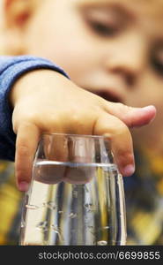 Child With Hand In A Water Glass