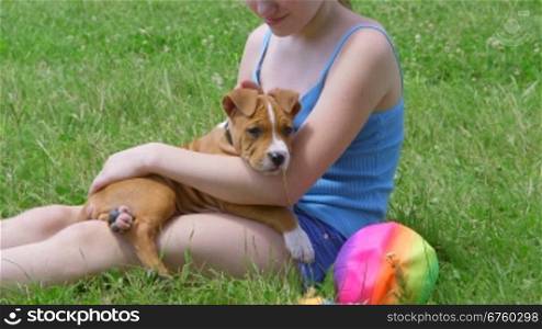 Child with her american staffordshire terrier puppy dog outdoor