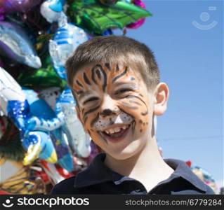 Child with painted face. Tiger paint. Boy on children&rsquo;s holiday