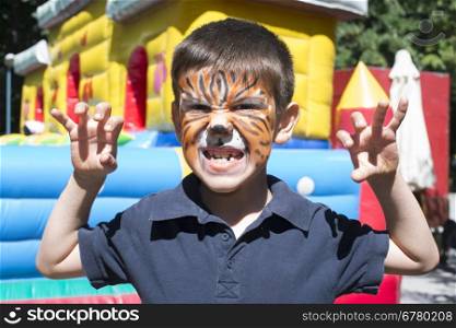 Child with painted face. Tiger paint. Boy on children&rsquo;s holiday