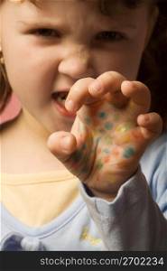Child with painted hand gesturing, portrait