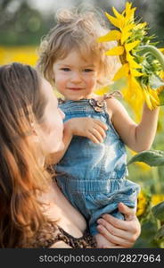 Child with sunflower in spring field