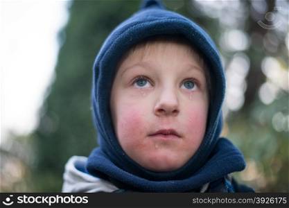 Child with tears. Child crying with tears below the eyes in winter