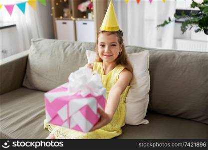 childhood and celebration concept - happy girl with gift box on party birthday at home. happy girl with gift box on birthday at home