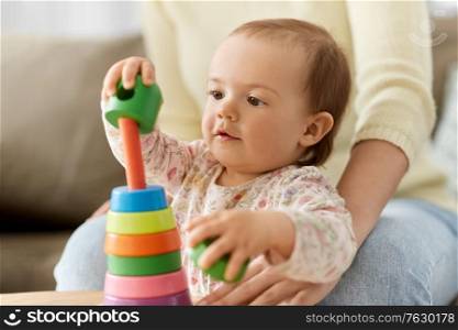 childhood and developing concept - lovely baby girl playing with toy pyramid at home. lovely baby girl playing with toy pyramid at home