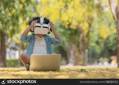 childhood and innovation concept - little african american curly hair girl searcing game in laptop for load to 3d gadget glasses.future technology for education in virtual reality, 3d gadget.