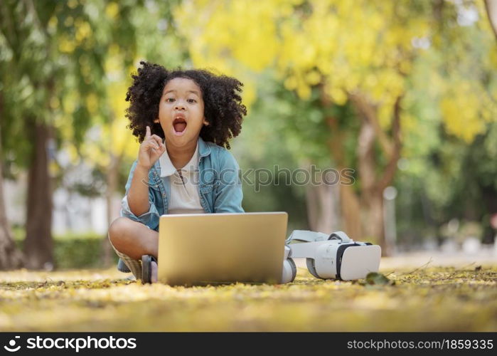 childhood and innovation concept - little african american curly hair girl searcing game in laptop for load to 3d gadget glasses.future technology for education in virtual reality, 3d gadget.