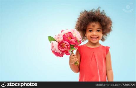 childhood and people concept - happy little african american girl with flowers over blue background. happy little african american girl with flowers
